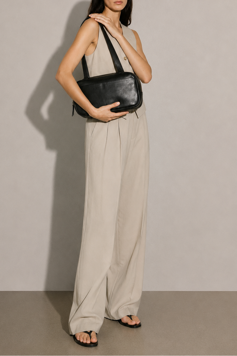 Leather Bowler bag in black full-grain leather. Has two shoulder straps and many interior pockets. It also has an outside pocket for a smartphone. 