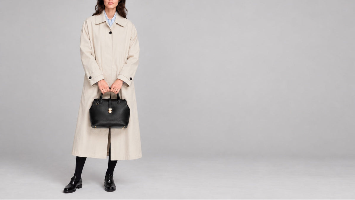 Model wearing a oversized designer jacket with black leather loafers and the TAH Doctor Bag top handle in black 