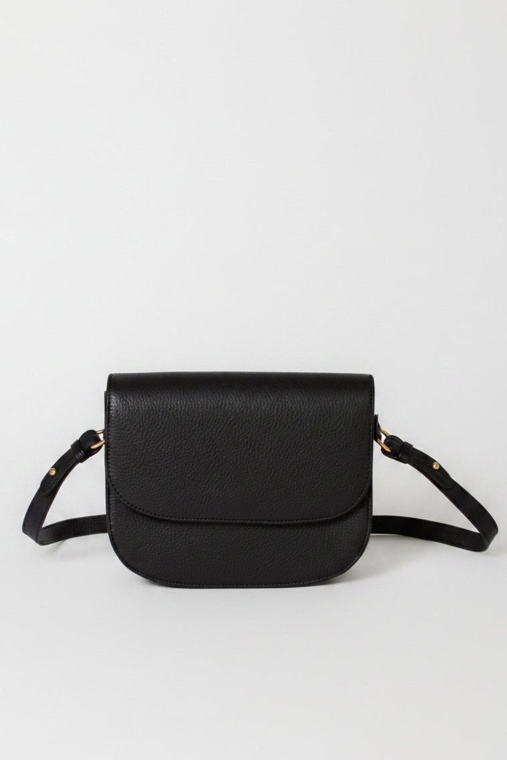 Leather Saddle bag in black full-grain leather, with a detachable crossbody strap, slight touches of gold hardware, and a flap magnetic closure 