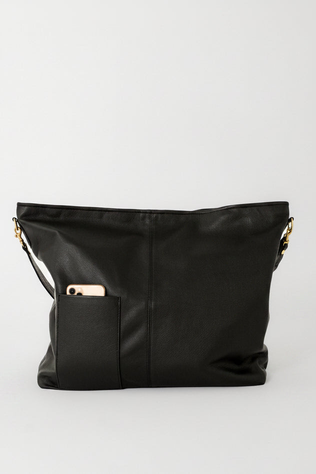 Handcrafted oversized leather tote bag in black with an outside pocket for your cell phone