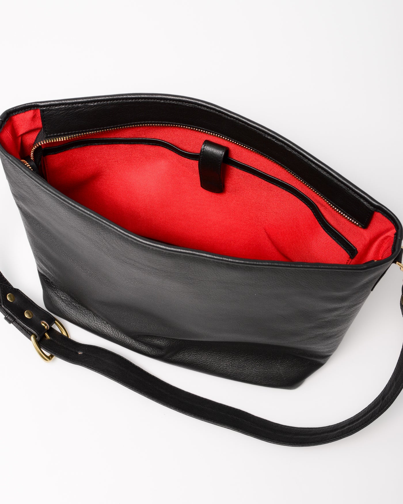 Black leather handbag with a red interior showing the tablet compartment. 