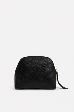A small black pebbled leather pouch with a gold zipper and a black wristlet strap, shown against a plain white background.