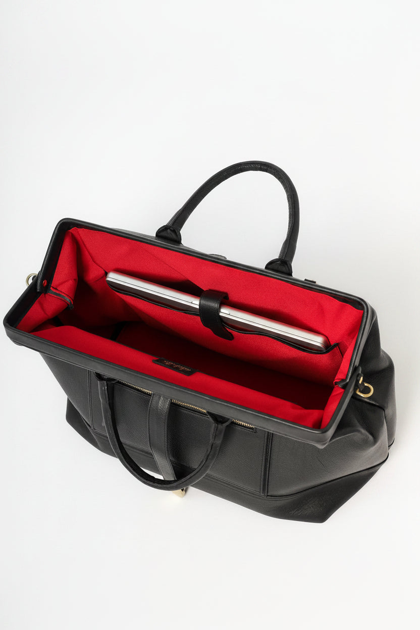 Handcrafted Leather Doctor bag with metal frame closure, gold hardware, gold feet, interior compartments, and an outside pocket for a smart phone. 