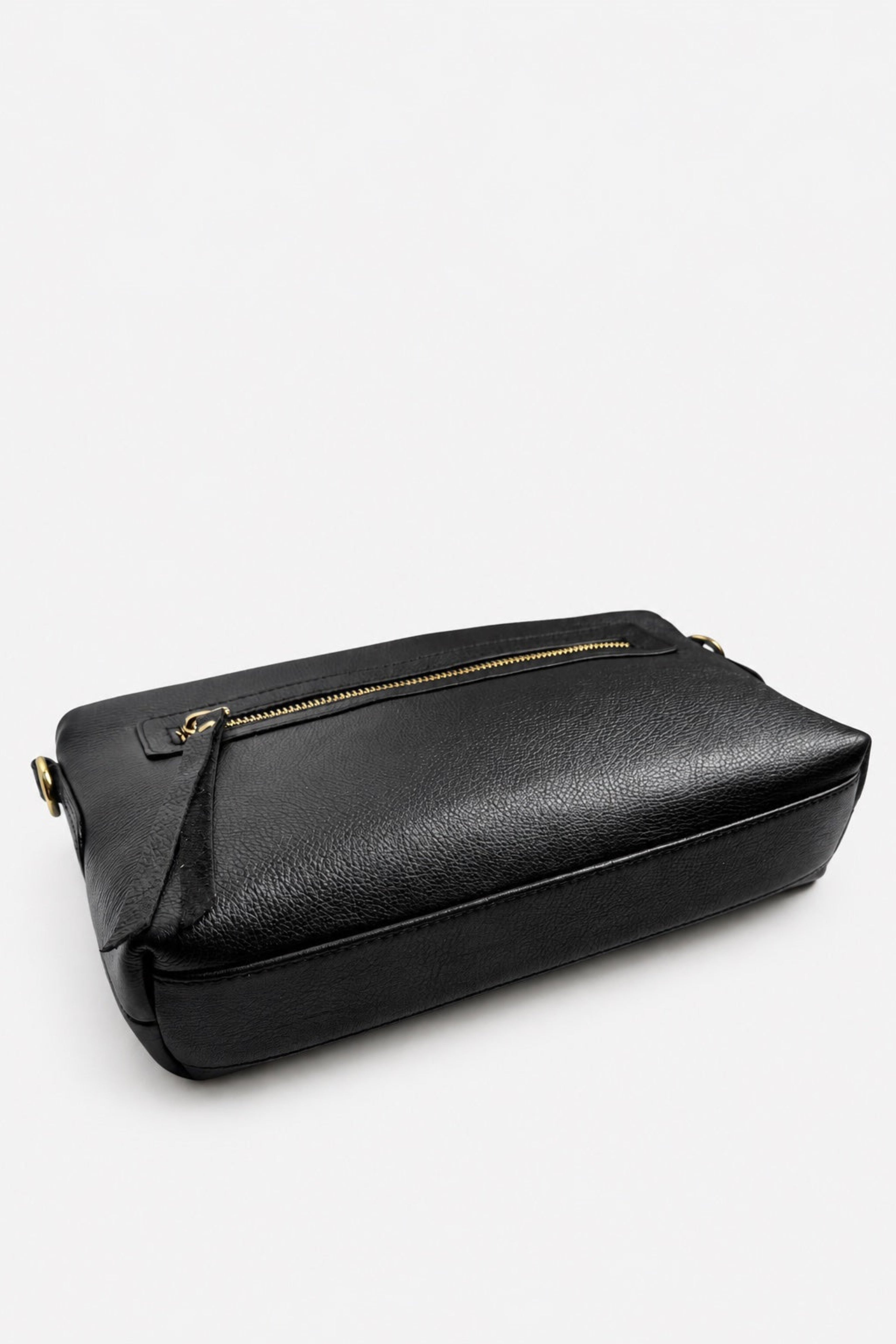 A black textured leather crossbody bag with a gold zipper and gold-tone hardware, photographed on a clean white studio background.