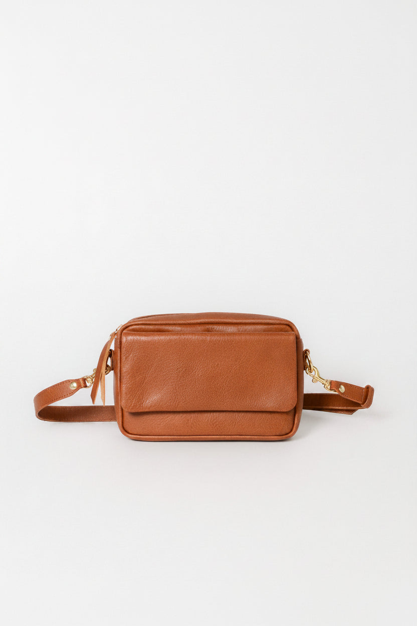 A small brown leather crossbody bag with a zippered front pocket and an adjustable shoulder strap, shown against a plain white background.