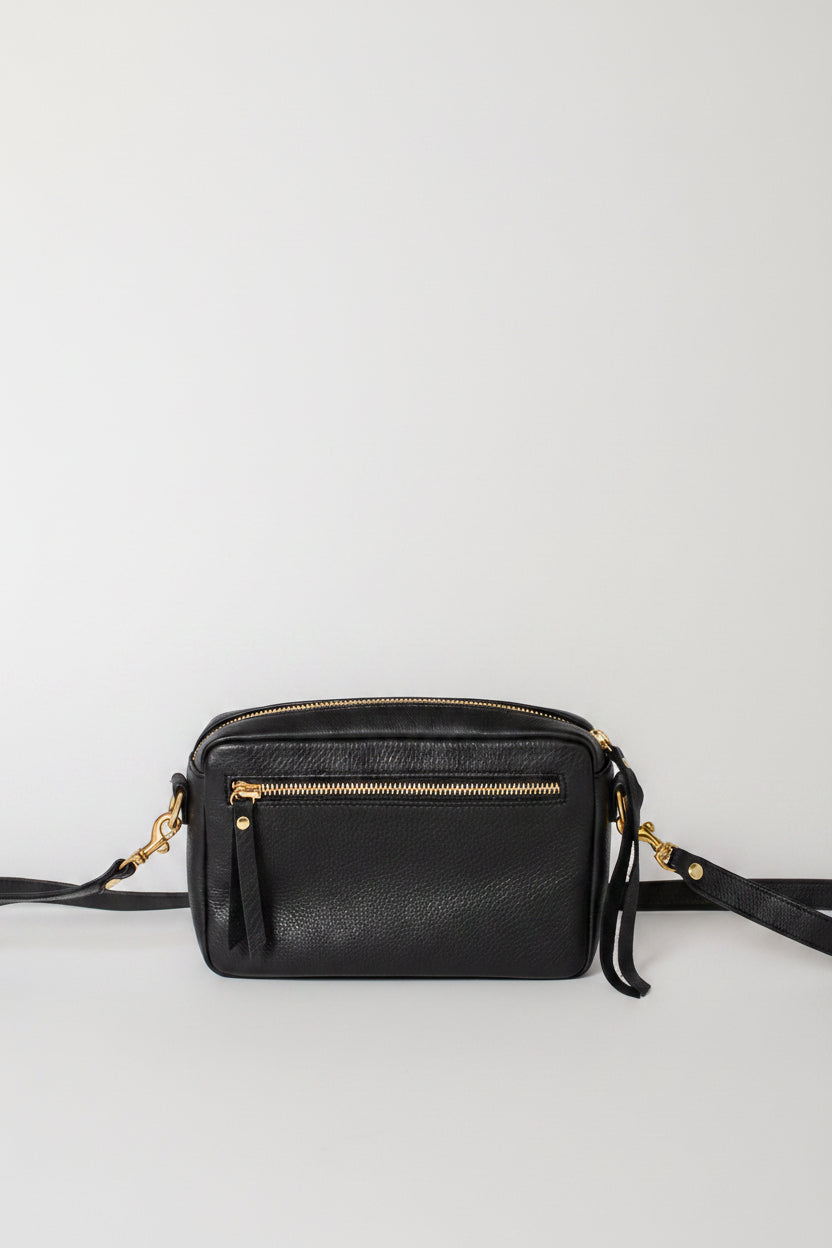 Ema Crossbody in black full grain leather showing the back zipper pocket with gold hardware details