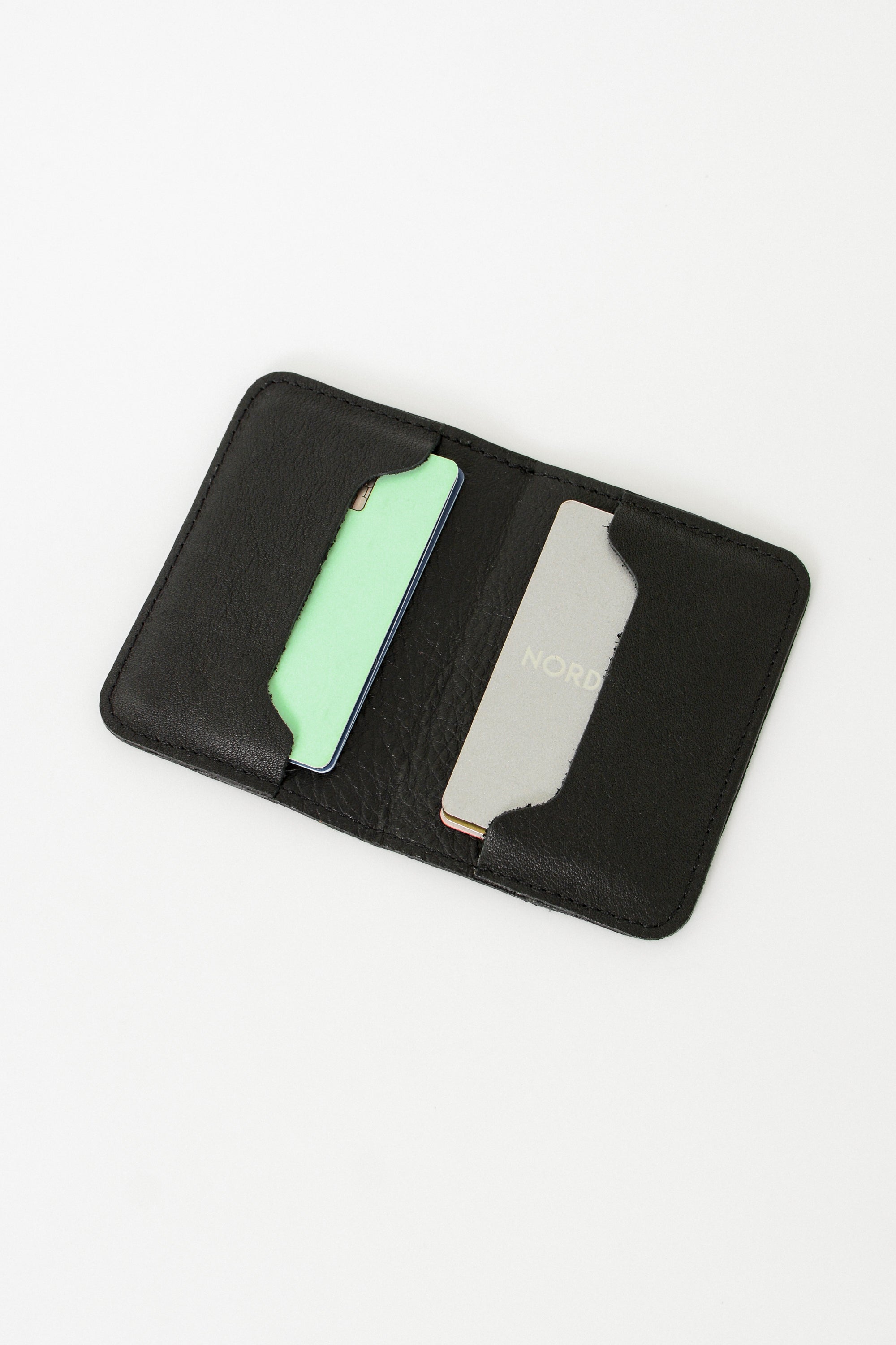 Fold over full grain leather wallet in the color black, a simple sleek design that holds up to 10 credit cards, and some cash