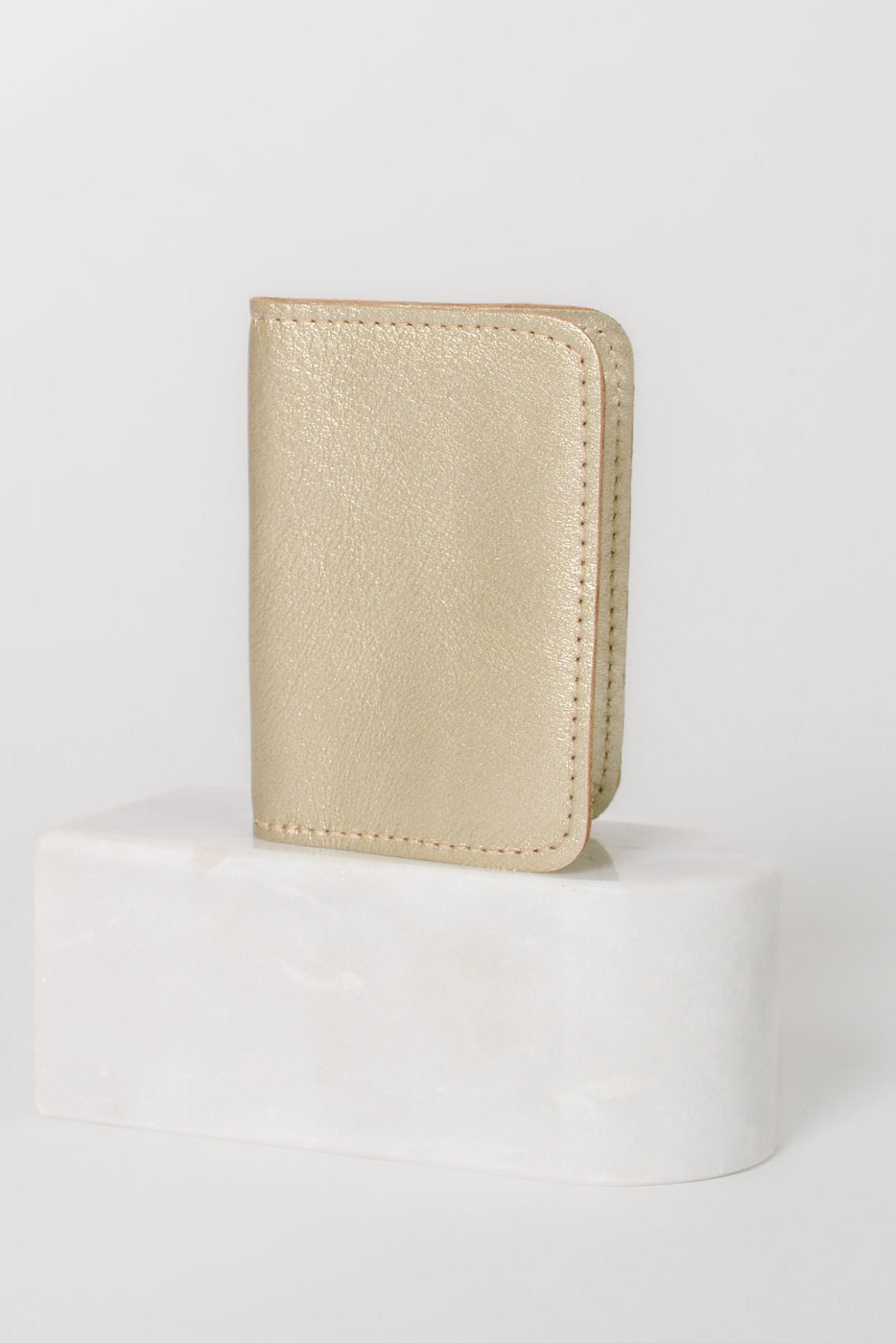 Fold over full grain leather wallet in the color metallic gold, a simple sleek design that holds up to 10 credit cards, and some cash