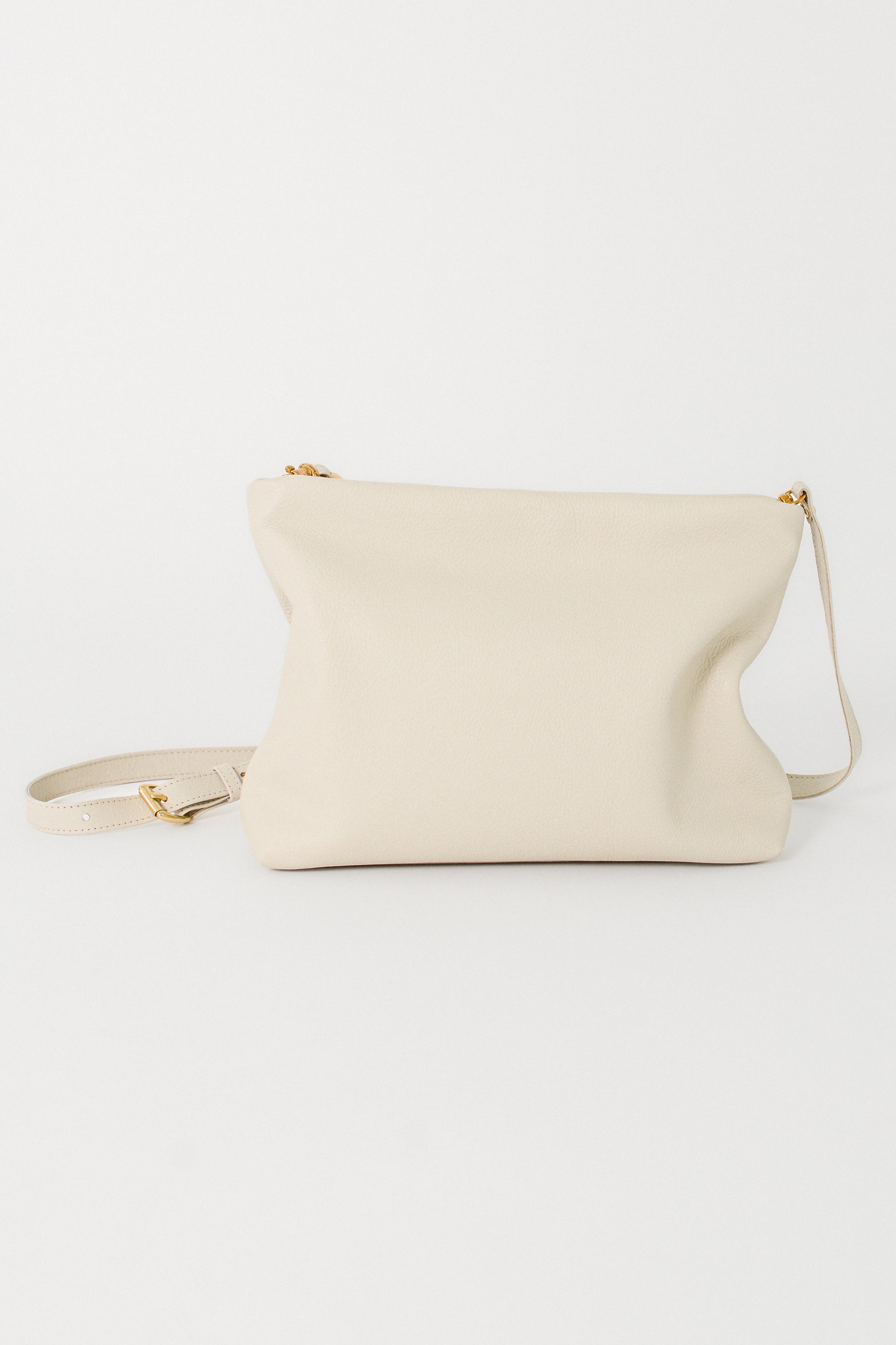 Off-white leather handbag with a crossbody strap on a white background