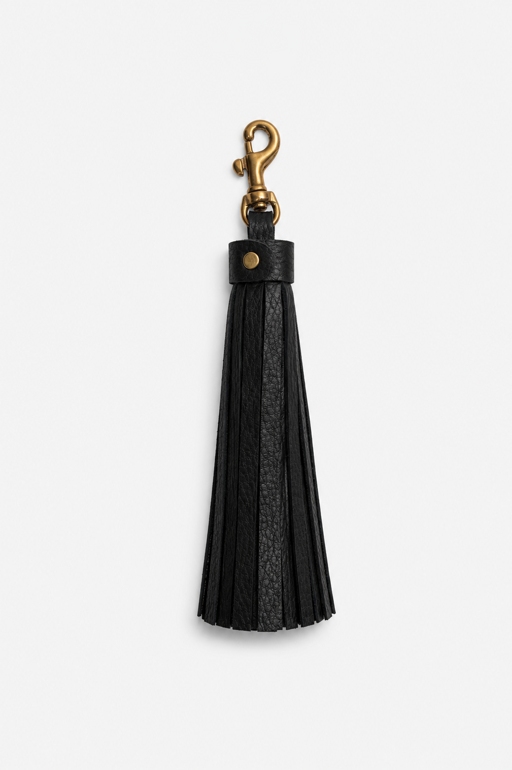 A black leather tassel keychain with a gold solid brass metal swivel clasp, shown against a plain light gray background.