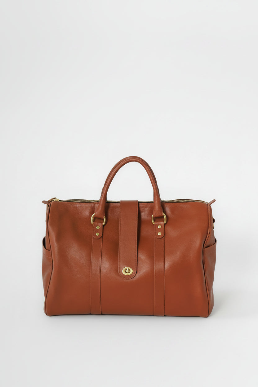 Loen Weekender Duffle in brown leather with two handles and gold solid brass hardware. 