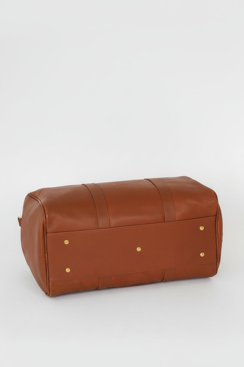 Loen Weekender Duffle in brown leather showing the solid brass feet from the bottom of the bag. 