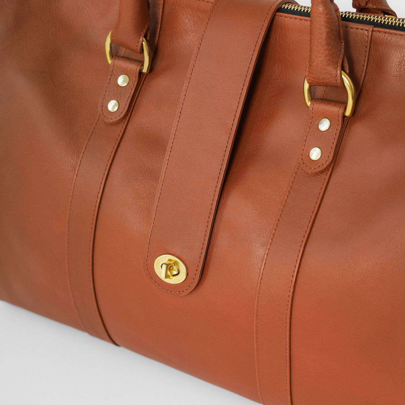 Loen Weekender Duffle in brown leather showing the details fo the solid brass hardware. 