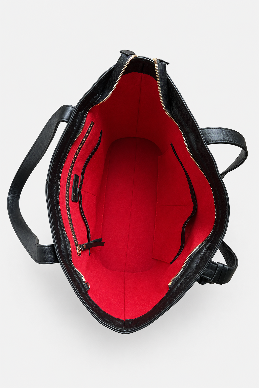 Black leather tote bag shown from a top-down view, highlighting its bright red interior lining with zippered pockets and a main compartment. This is the Megan Everyday Tote bag.