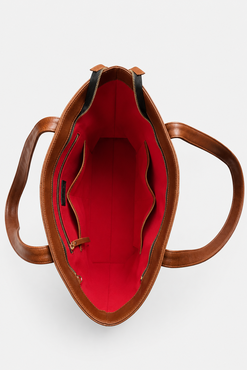 Top-down view of a brown leather tote bag showing its bright red interior lining and double shoulder straps on a light gray background. This is the Megan Everyday Tote Bag in the color whiskey.