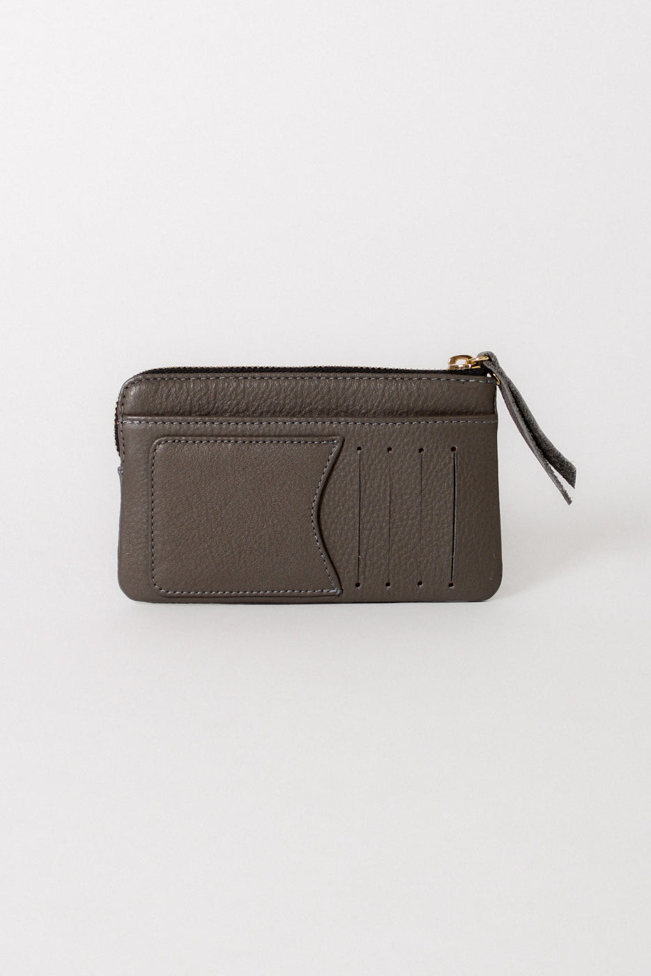 A dark grey textured leather zip-around card holder with multiple card slots and a small leather tassel pull, shown on a light gray background.