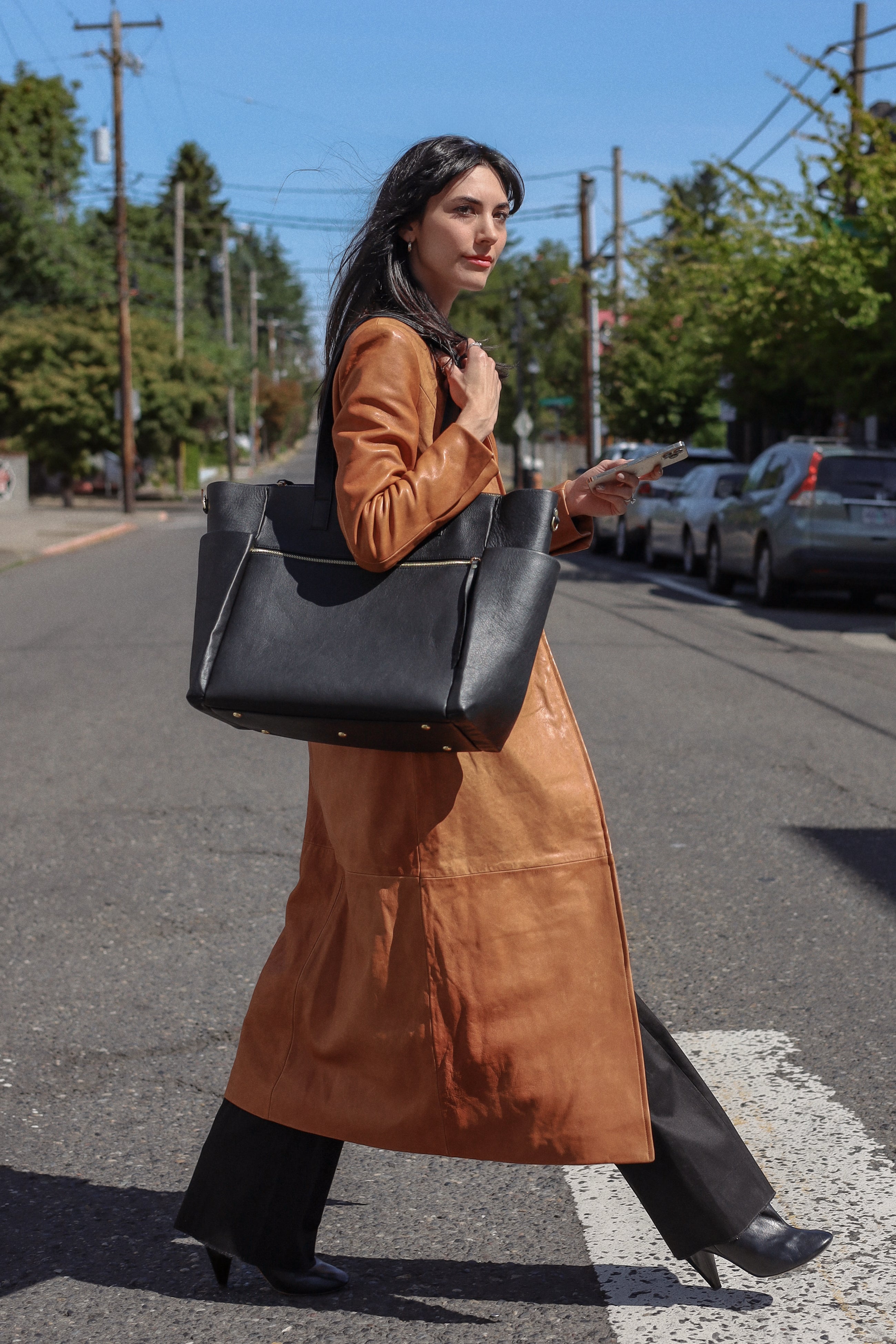 Miranda Work Traveler Tote in full-grain leather with brass hardware, structured silhouette, padded laptop sleeve, luggage pass-through, and organized compartments.