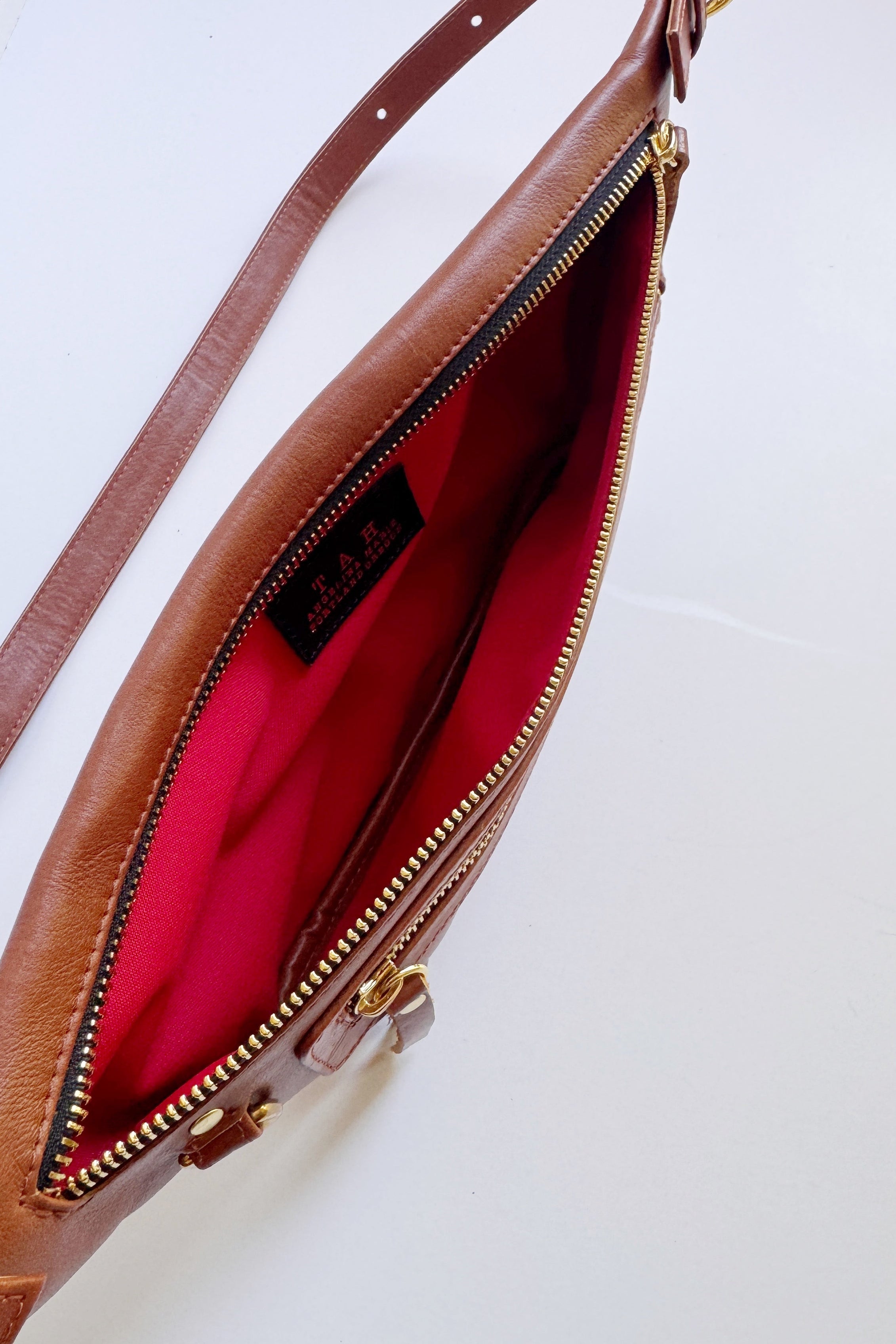 Leather Sling bags for travel and everyday use. This image shows the red interior lining of the bag. This style can also be worn as a fanny pack around the waist 
