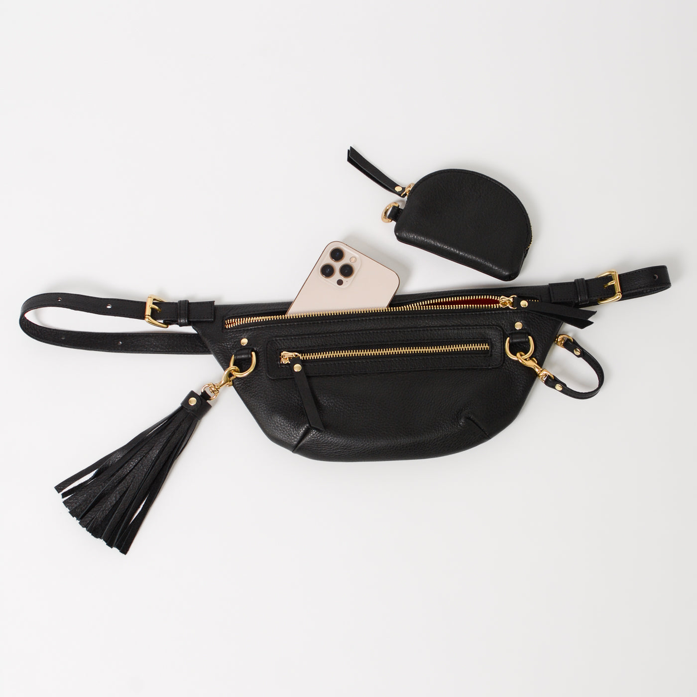 Black leather fanny pack belt bag with multiple zip pockets and gold hardware, shown with phone and small pouch to highlight organized storage for everyday essentials and travel.