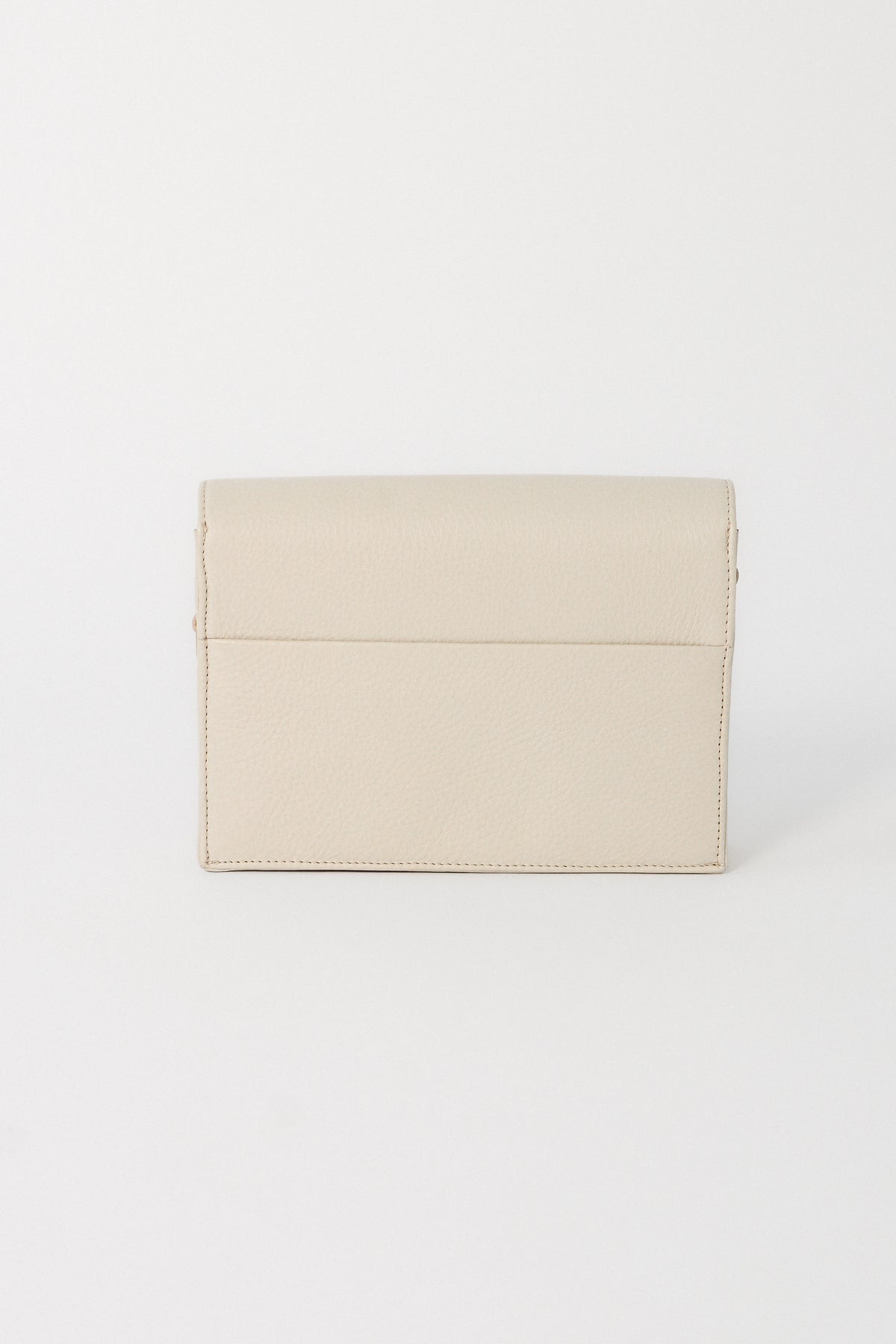 Off-white leather handbag on a white background. This is the back for the Nora Crossbody