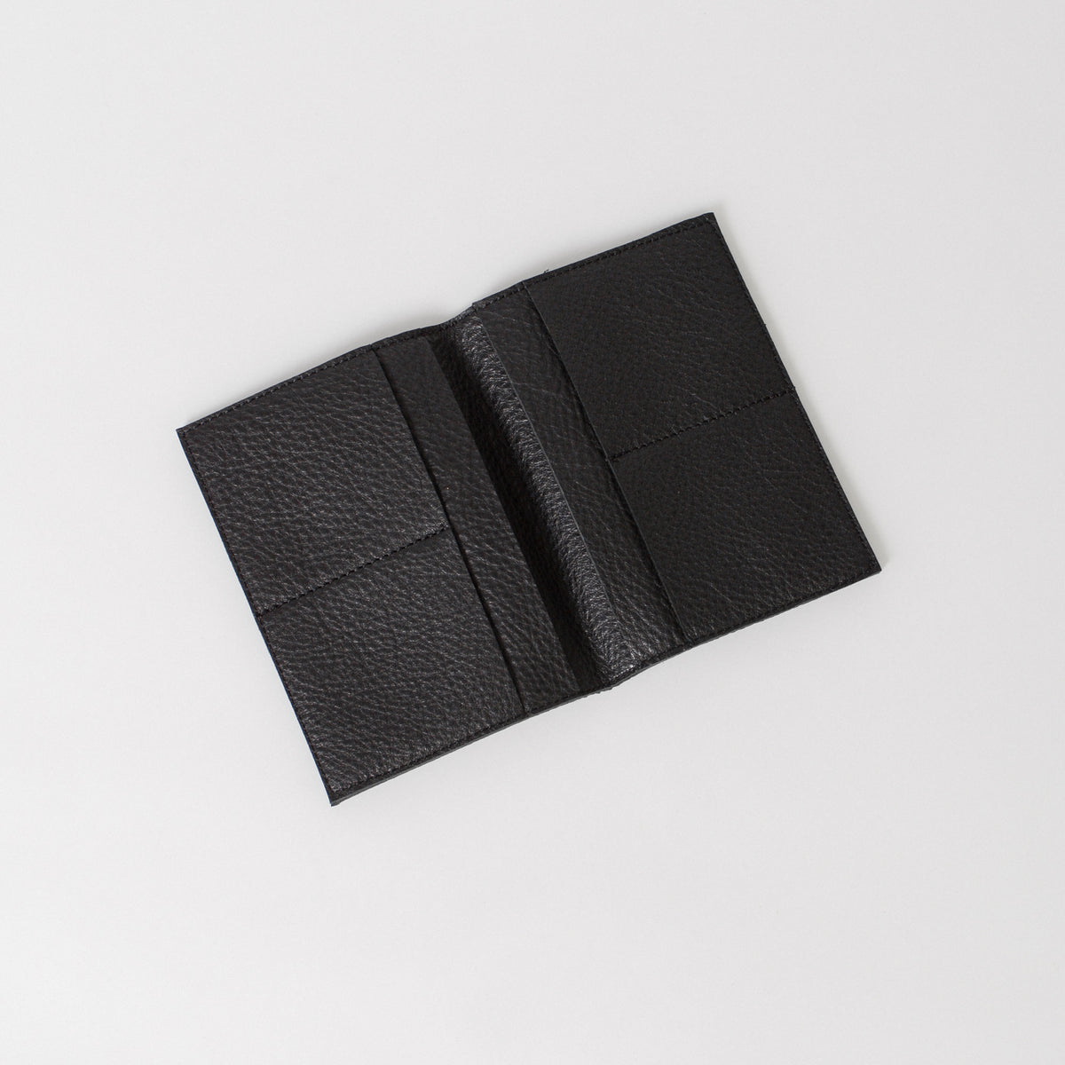 A black leather passport wallet showing the interior pockets.