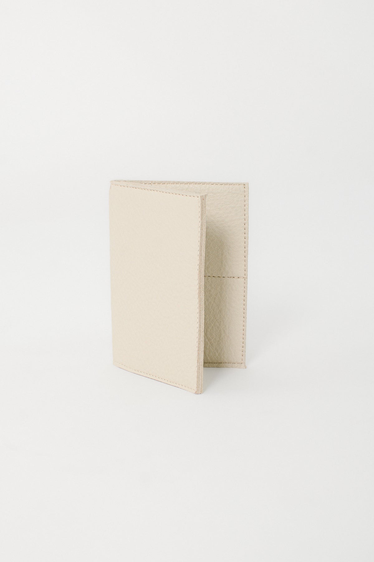 Beige leather passport wallet on a white background.
