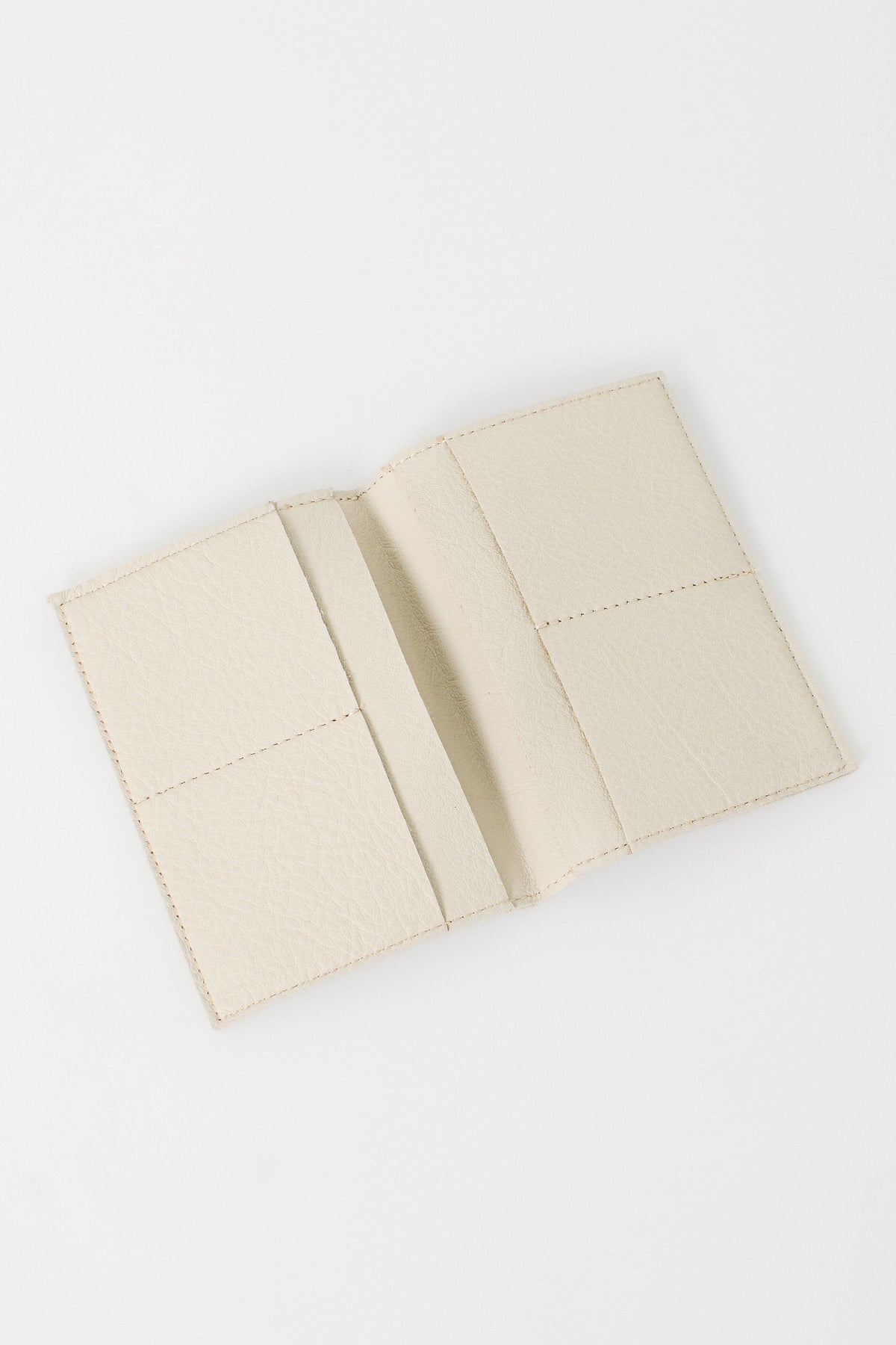 Beige leather passport wallet on a white background.