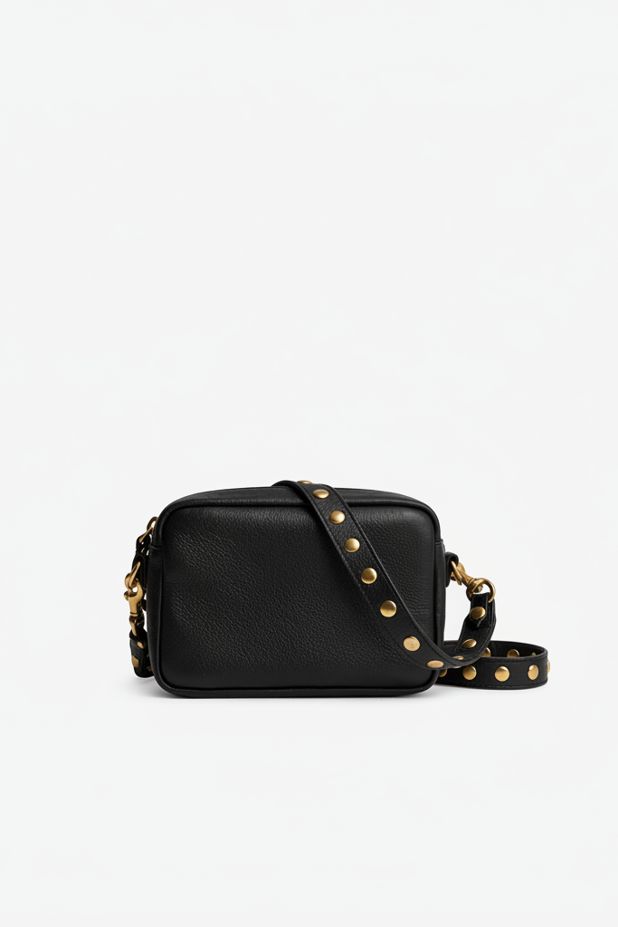 Small black leather Ami Crossbody bag with a compact rectangular shape and gold-studded strap, designed for carrying essentials and ideal for concerts and events.