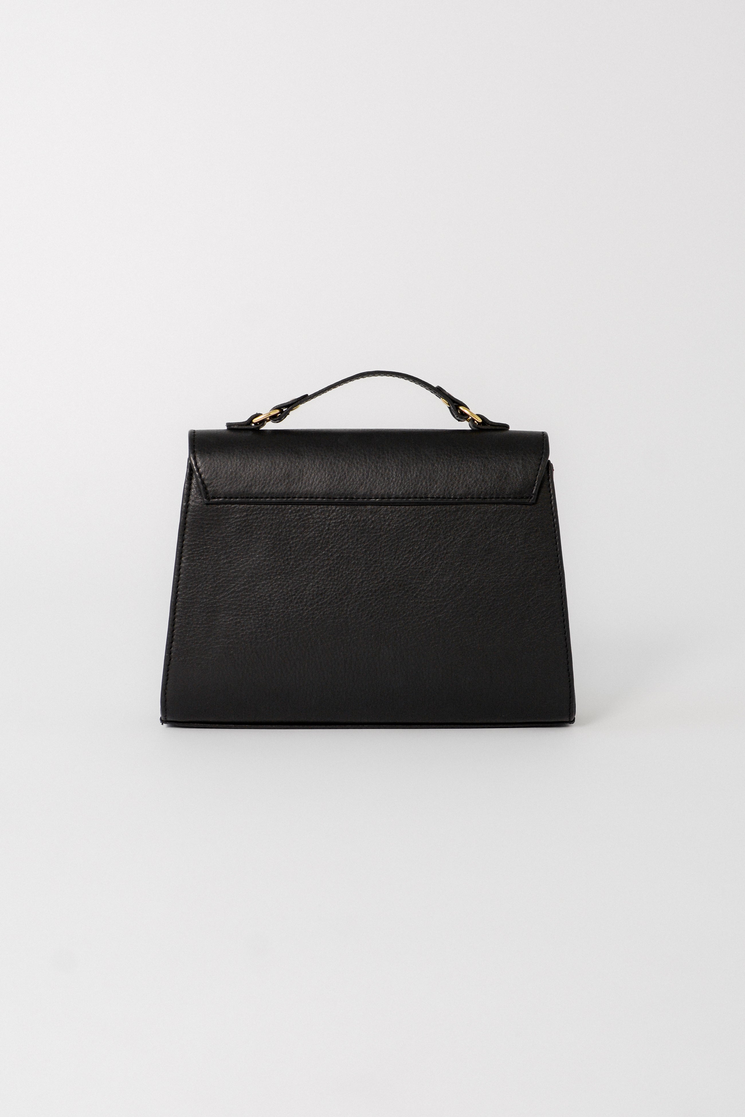 Back view of the black leather Carrie Petite top-handle bag, highlighting its structured shape, smooth leather finish, and clean, minimal design for versatile day-to-evening wear.