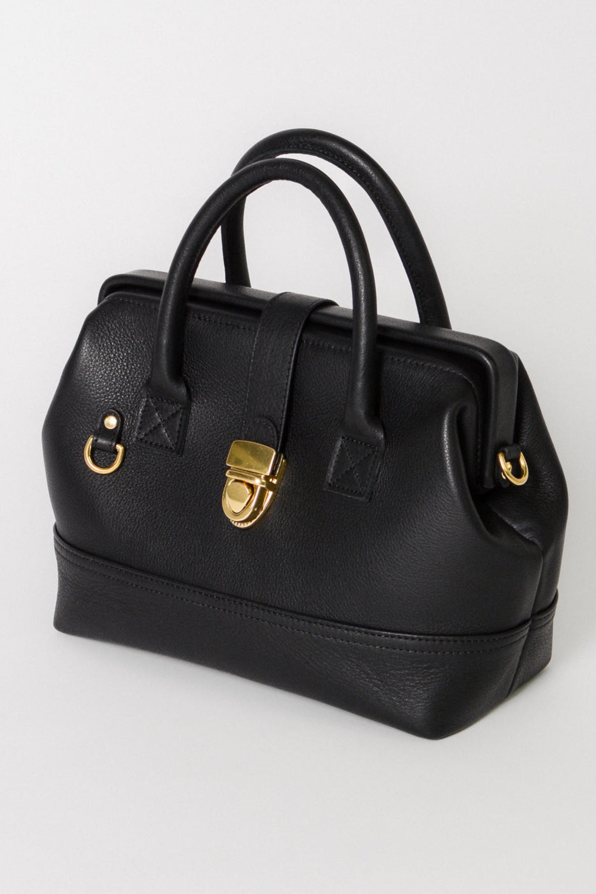 Front view of the Doctor Bag in black leather, featuring structured top handles, a signature gold lock closure, and a clean, architectural silhouette.