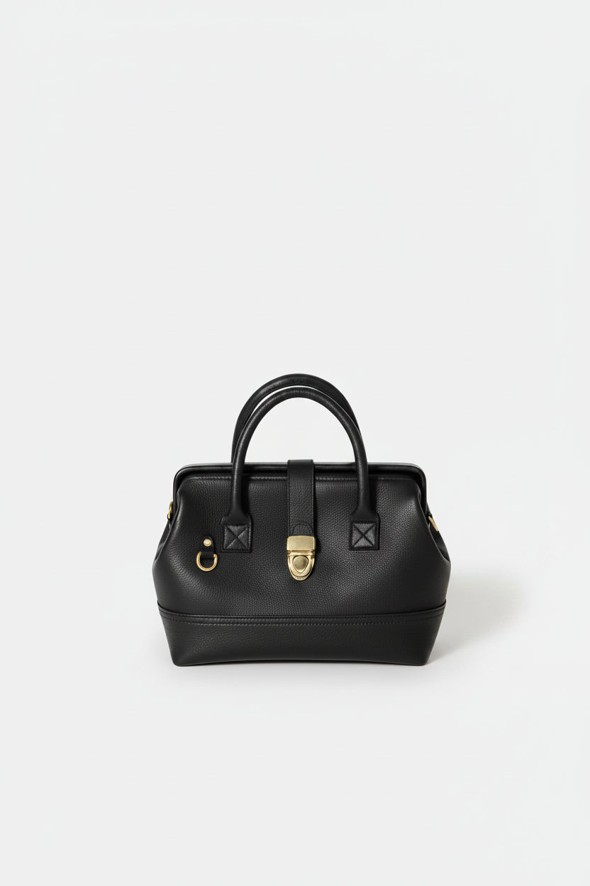 Front-facing hero image of the Doctor Bag in black leather, featuring structured top handles, a framed silhouette, and a polished gold clasp closure.