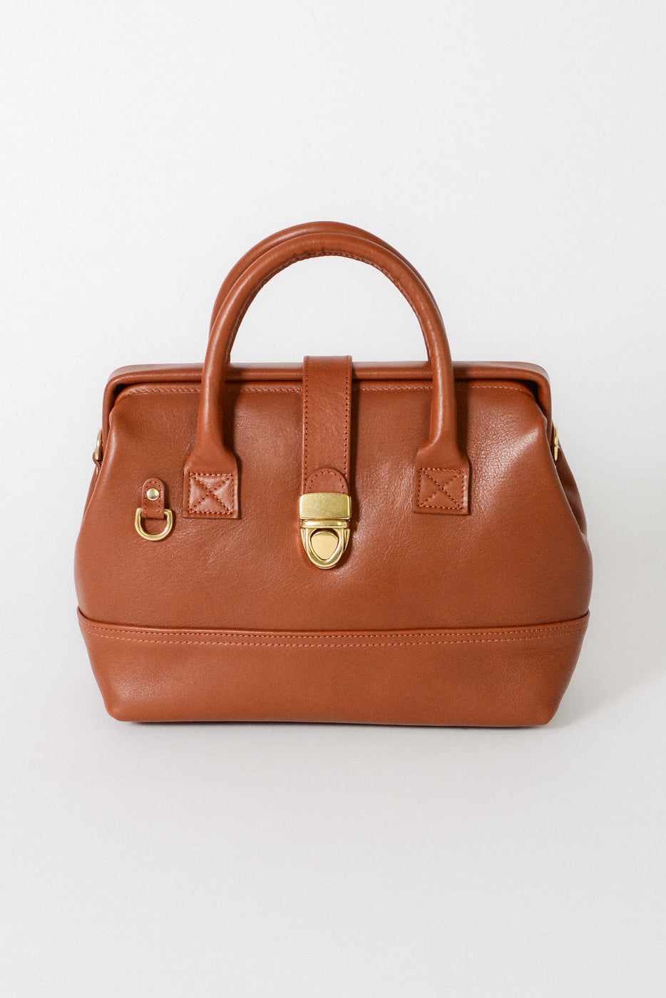 Front view of the Doctor Bag in cognac leather, featuring structured top handles, a signature gold lock closure, and a clean, architectural silhouette.
