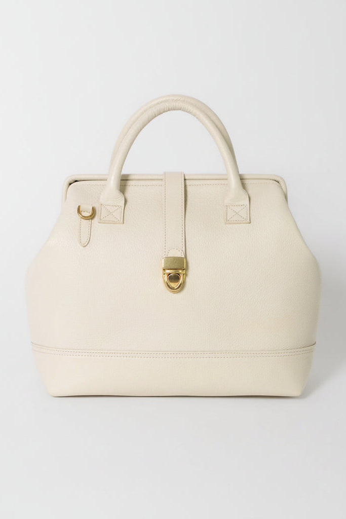 Front view of the Doctor Bag in cream pebbled leather with structured top handles, gold hardware, and vintage-inspired clasp closure.