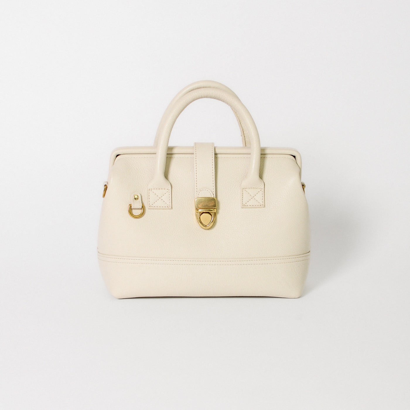 Front view of the Doctor Bag Petite in ivory leather, featuring structured top handles, a signature gold lock closure, and a clean, architectural silhouette.