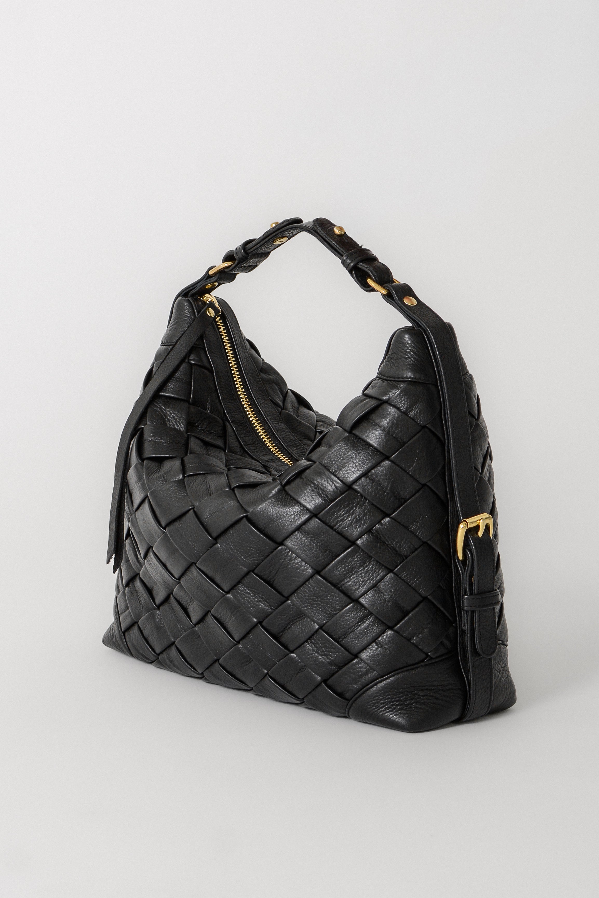 Black Selena Handwoven leather bag shown with the shorter shoulder strap, highlighting the woven construction, structured silhouette, and gold hardware details.