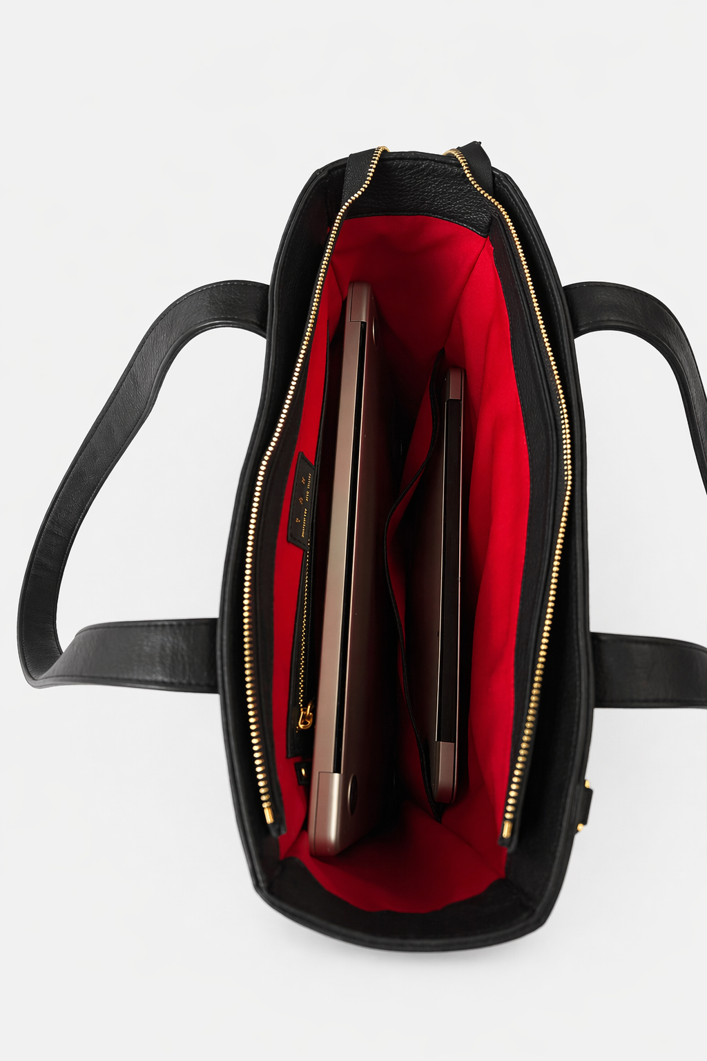 Interior of the Emily Tote showing organized compartments with space for  laptops, including a dedicated sleeve that fits up to a 13-inch laptop, finished with signature red lining.