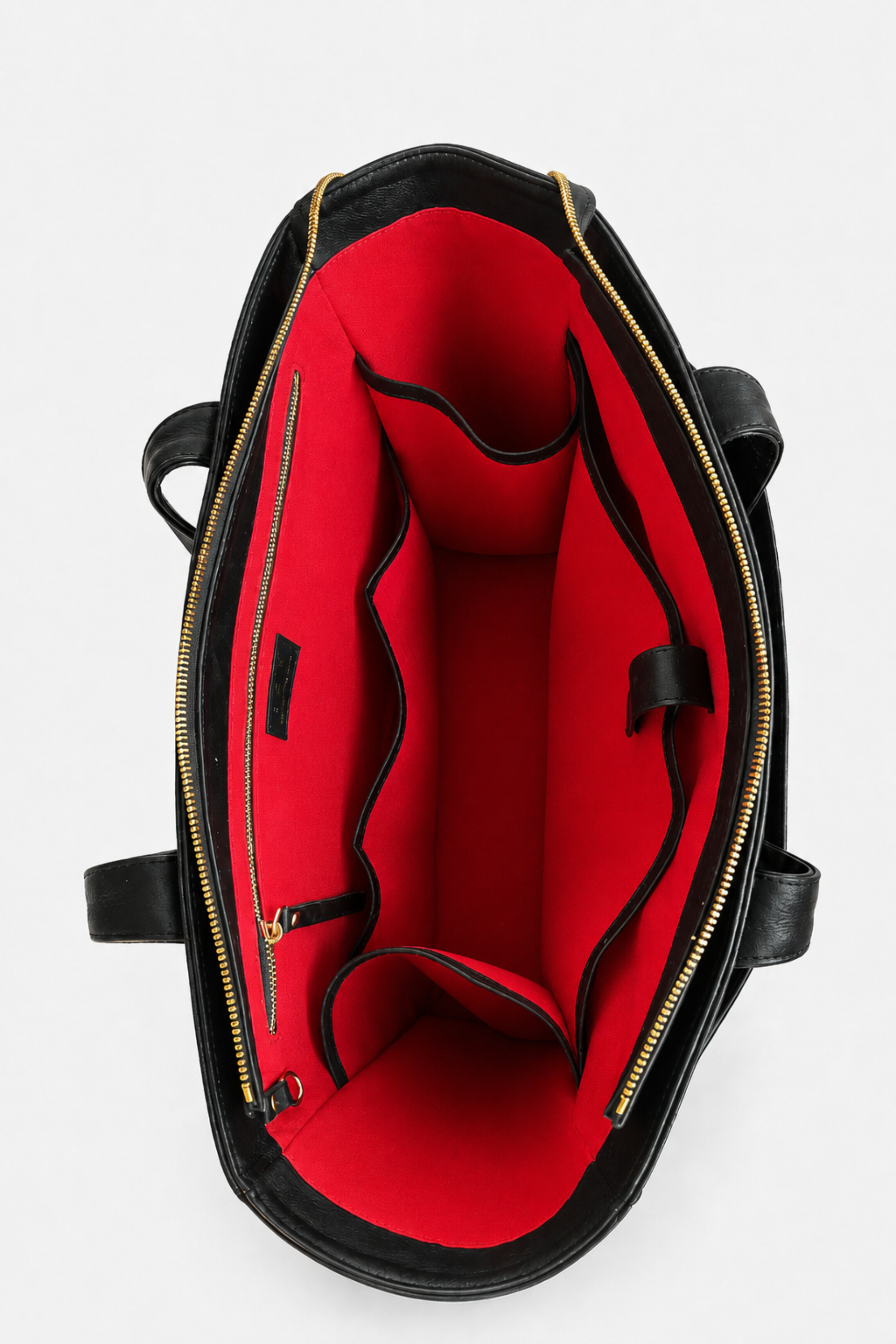 Interior of the TAH Mari Oversized Structured Tote in black full-grain leather with red lining, a zip pocket, and organized compartments including a compartment for your shoes, laptop, and more. 