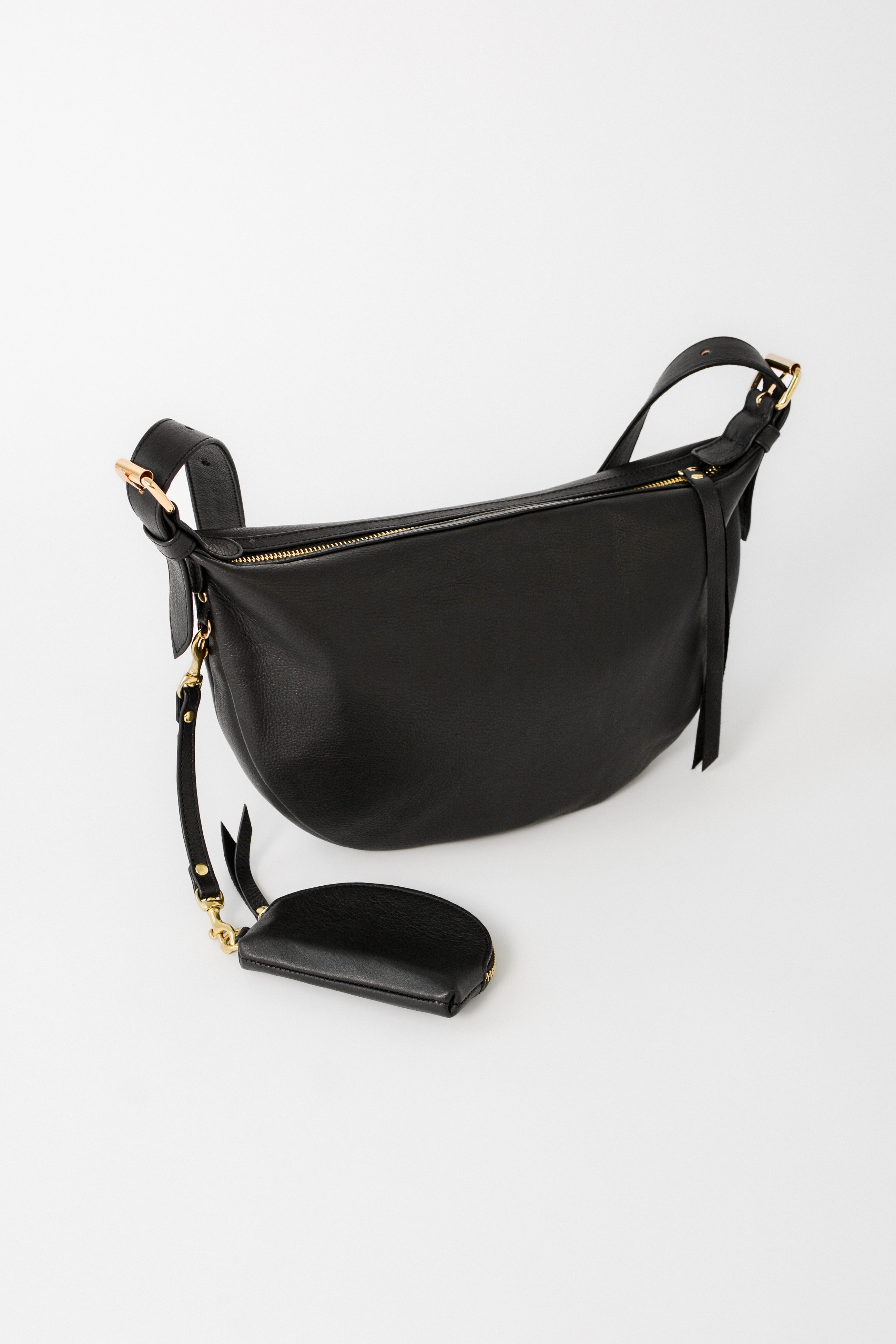Black leather Nova Sling Bag shown with detachable strap and matching accessory pouch, designed for versatile everyday organization.