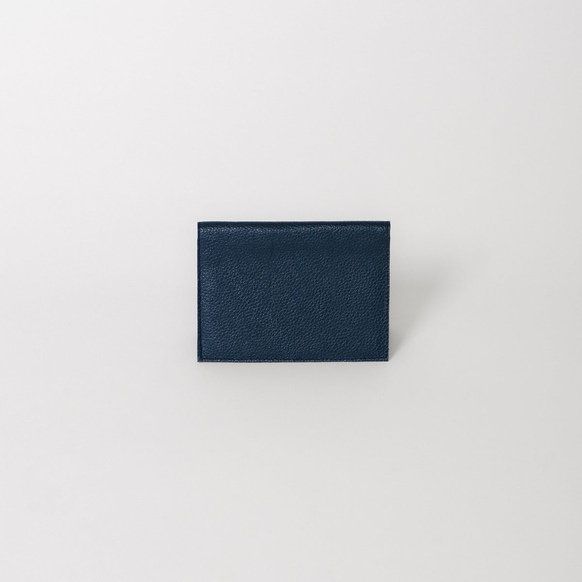 A leather passport wallet in the color marina blue.