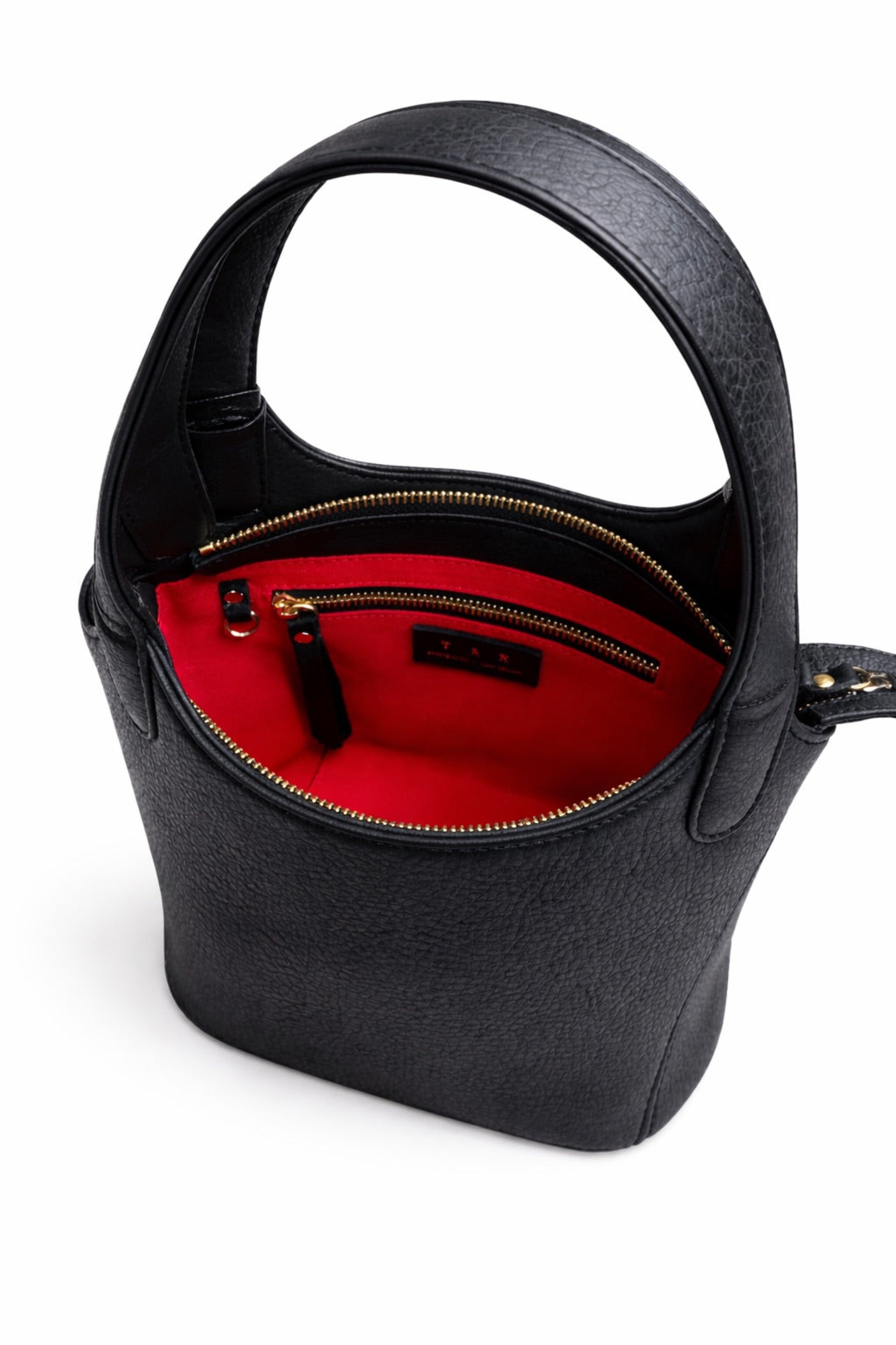 Interior of black leather Phoebe bucket bag showing red lining, interior zip pocket, and structured opening with gold hardware and a dring to attach your keys